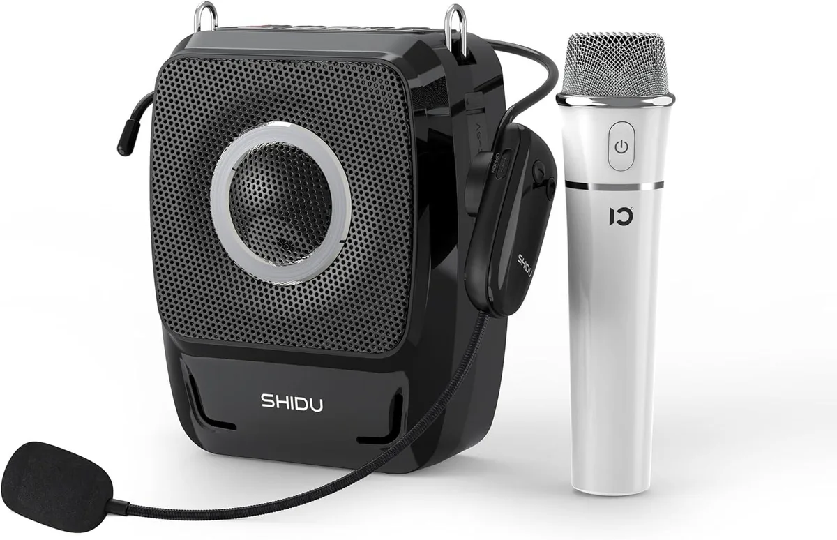 Compact rectangular speaker in dark finish with two visible drivers, bundled handheld mic and headset mic attached