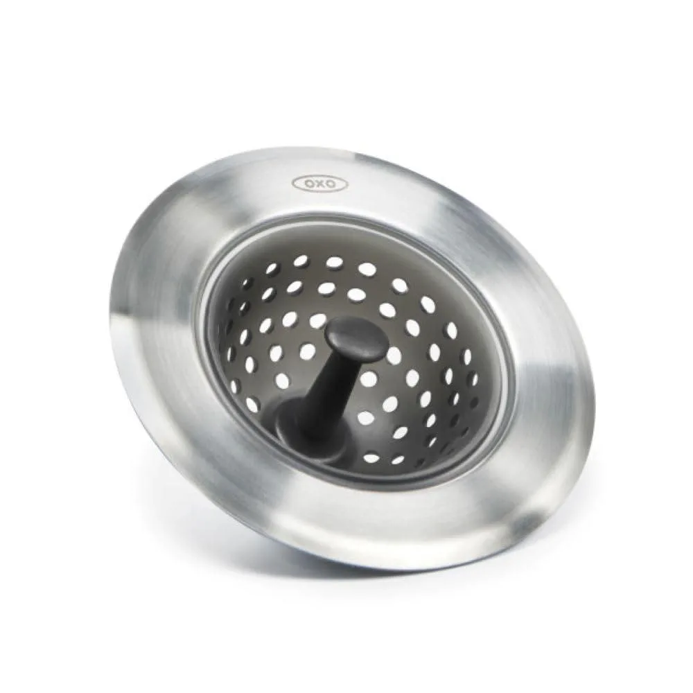 White silicone basket inside a stainless steel rim sitting in a sink drain