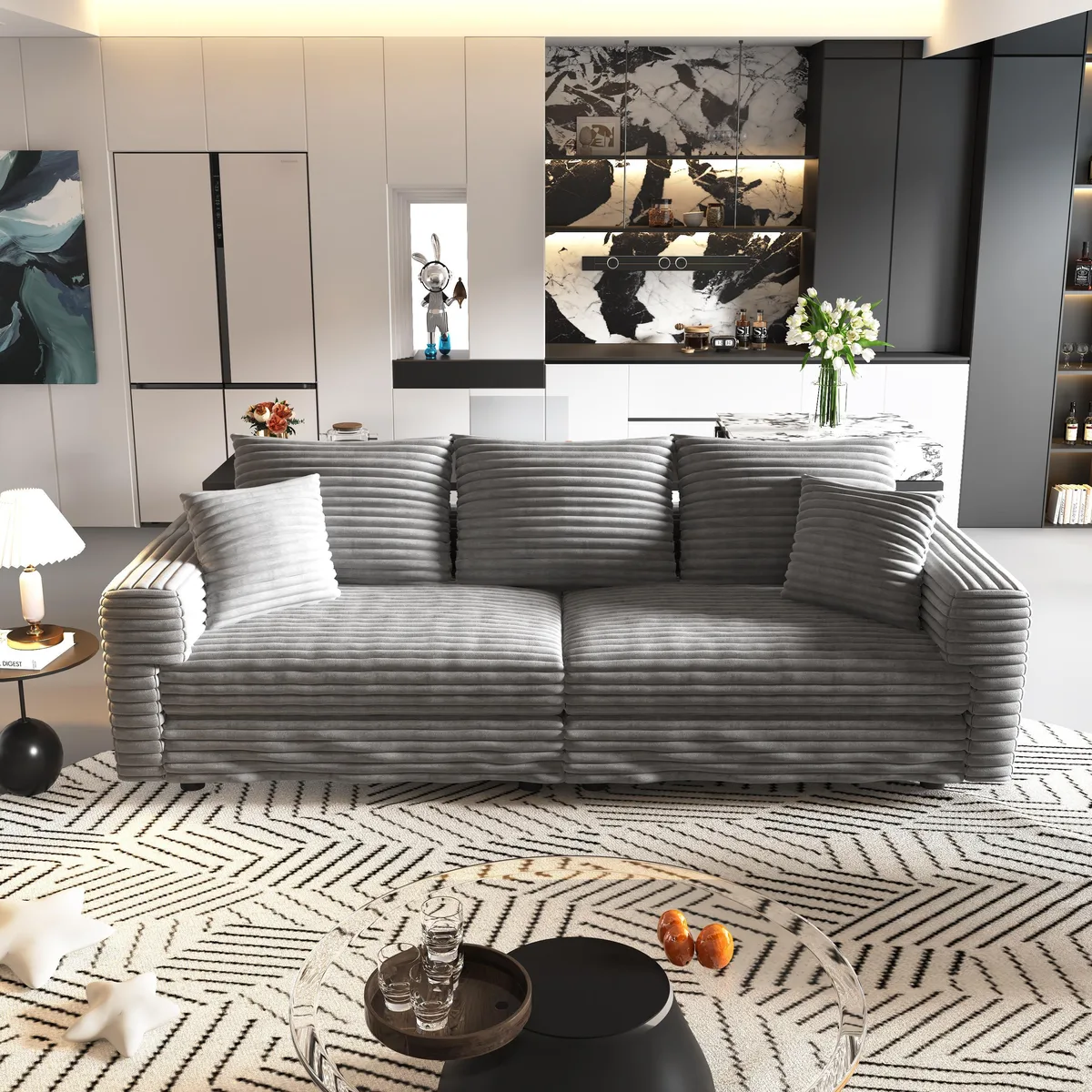 Grey plush corduroy three-seat sofa with deep cushions and matching ottomans