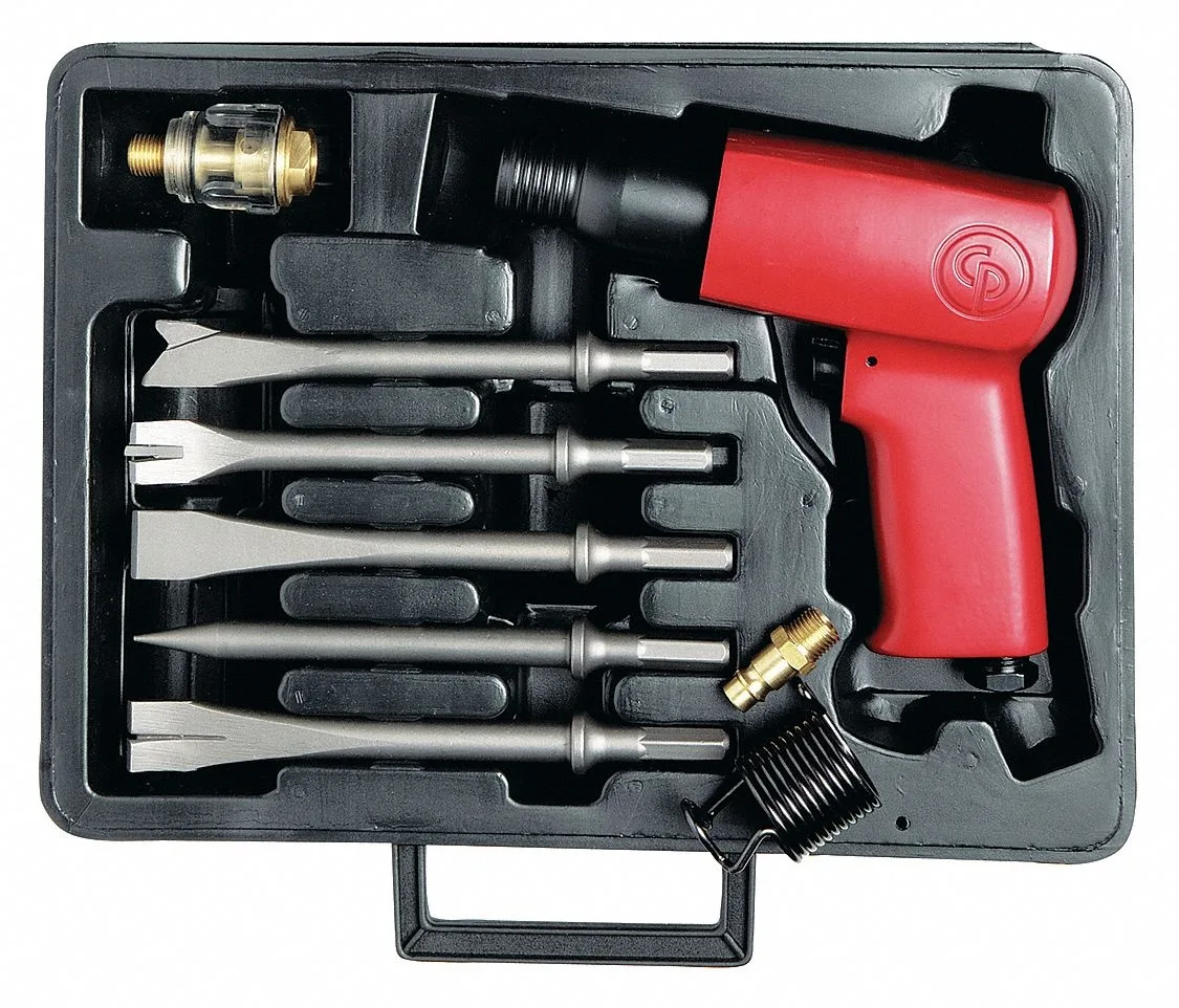 Red metal air hammer with round shank and quick-change retainer in black case with chisels and oiler