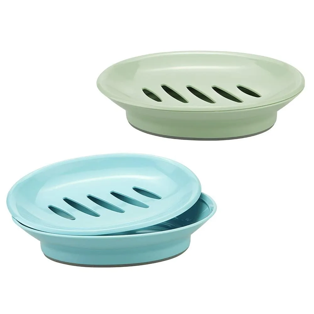Two rectangular plastic soap dishes, one blue and one green, each with a slotted upper tray that lifts off a solid base for drainage
