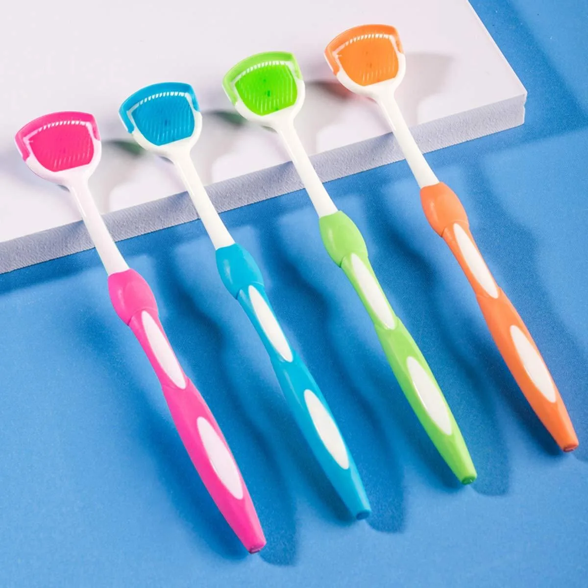 Four coloured tongue scrapers in blue green orange red