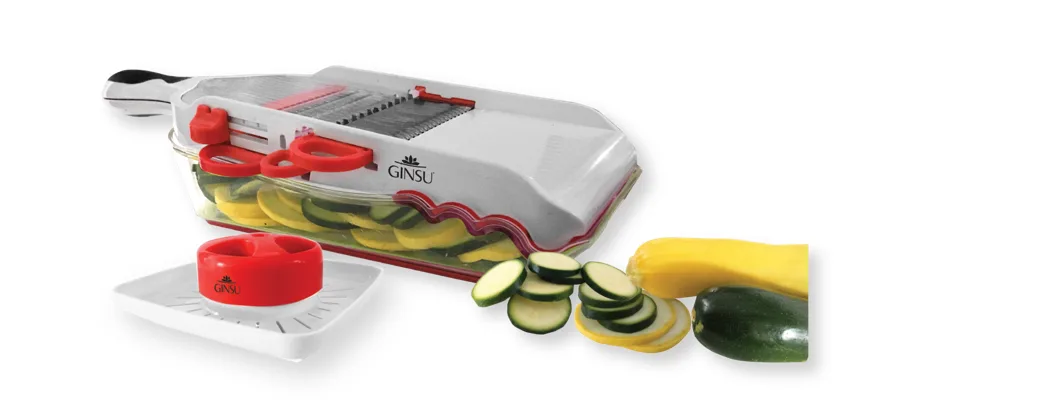 White plastic mandolin slicer with grey soft-grip handle, four interchangeable blades, thickness dial, clear food tray and hand guard