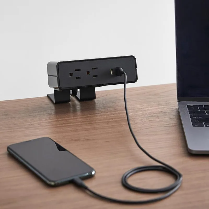 Black desktop charging hub with adjustable clamp, two AC outlets, USB-A and USB-C ports