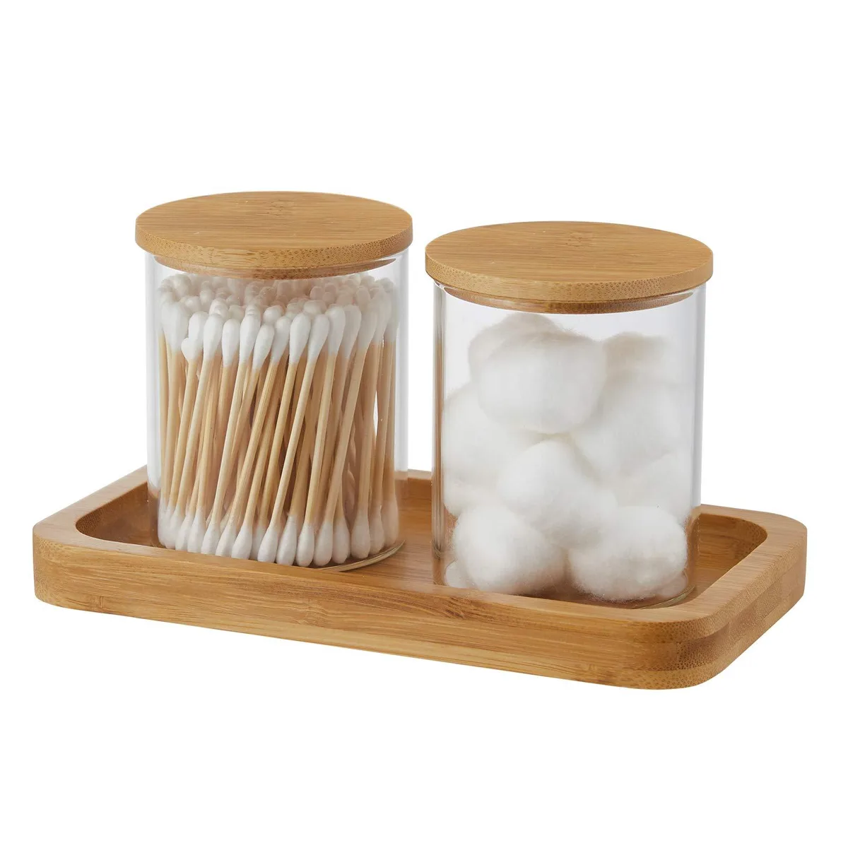 Two clear glass jars with bamboo lids on a rectangular bamboo tray