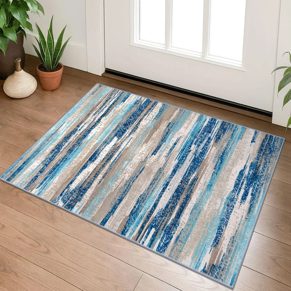 Small rectangular runner rug in aqua blue, denim blue, beige taupe and white abstract print, low pile with non-slip rubber backing
