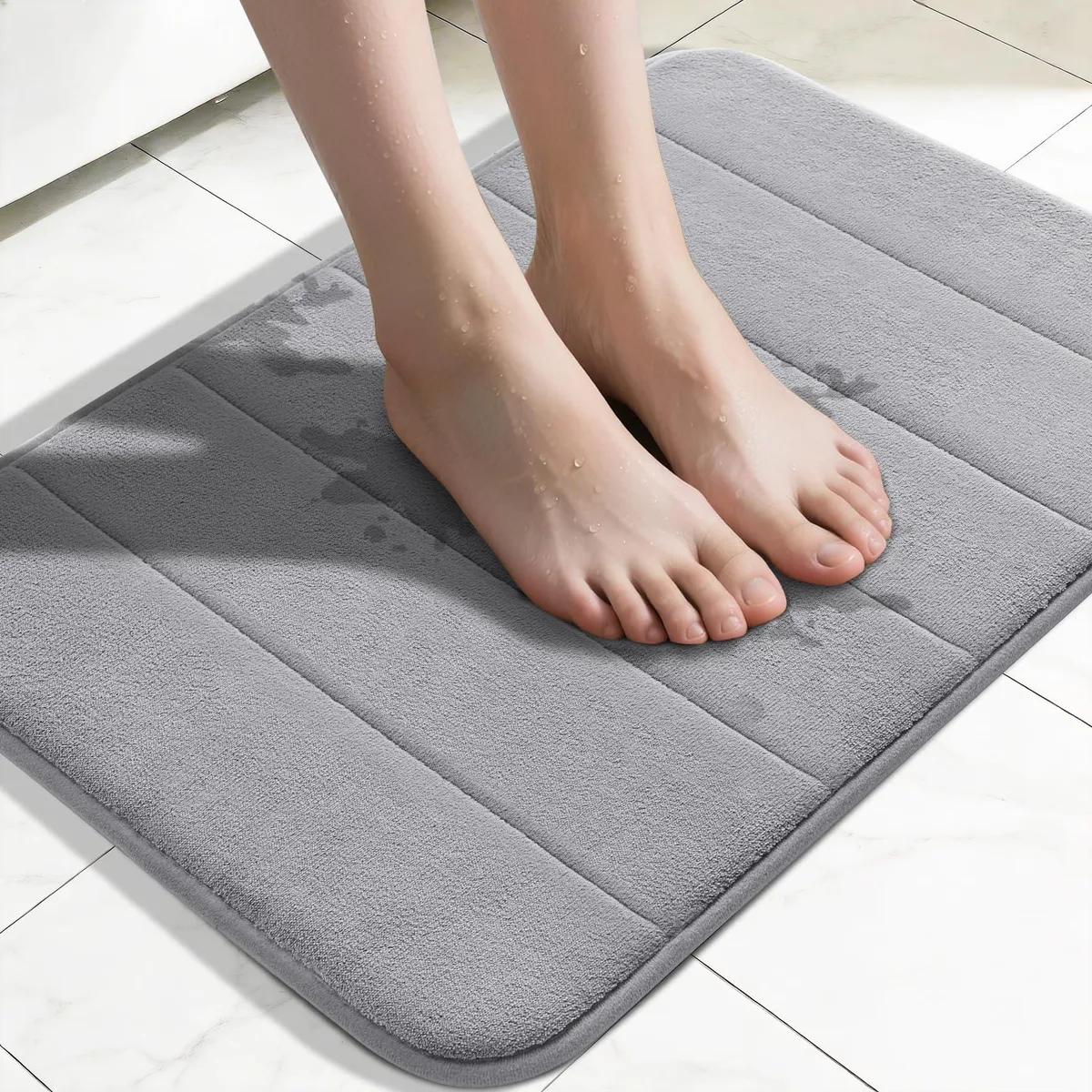 Rectangular grey bath mat with textured surface and folded edges