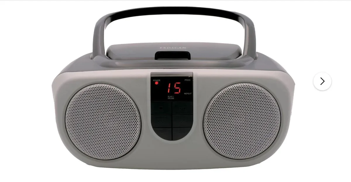 Silver portable CD boombox with AM/FM radio, LED display, top-loading disc slot, carry handle, aux input