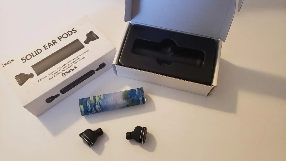 Small white wireless ear pods with matching rectangular charging case