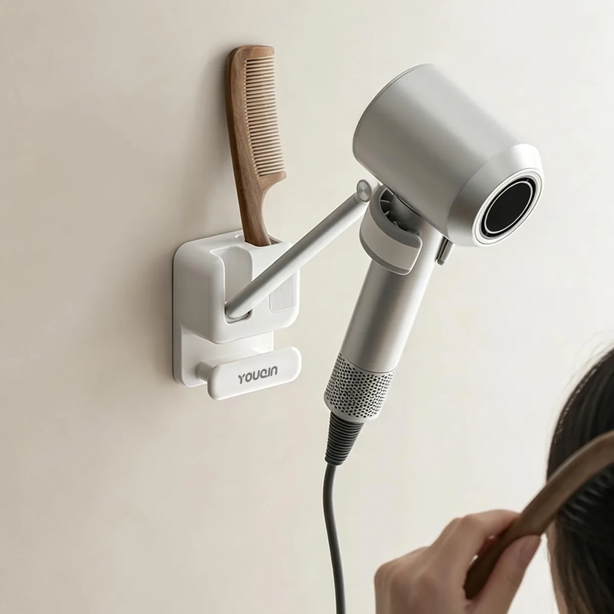 White wall-mounted hair dryer holder with adjustable arm, silicone clamp, comb slot and cord hook