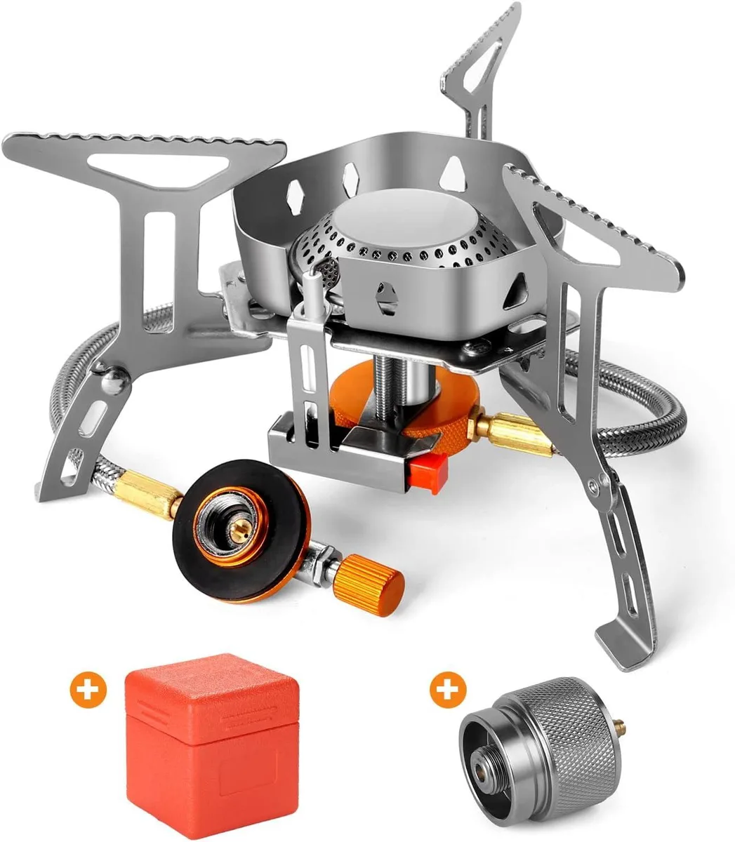 Compact silver camping stove with folding legs and windshield, piezo igniter button visible, carry case included