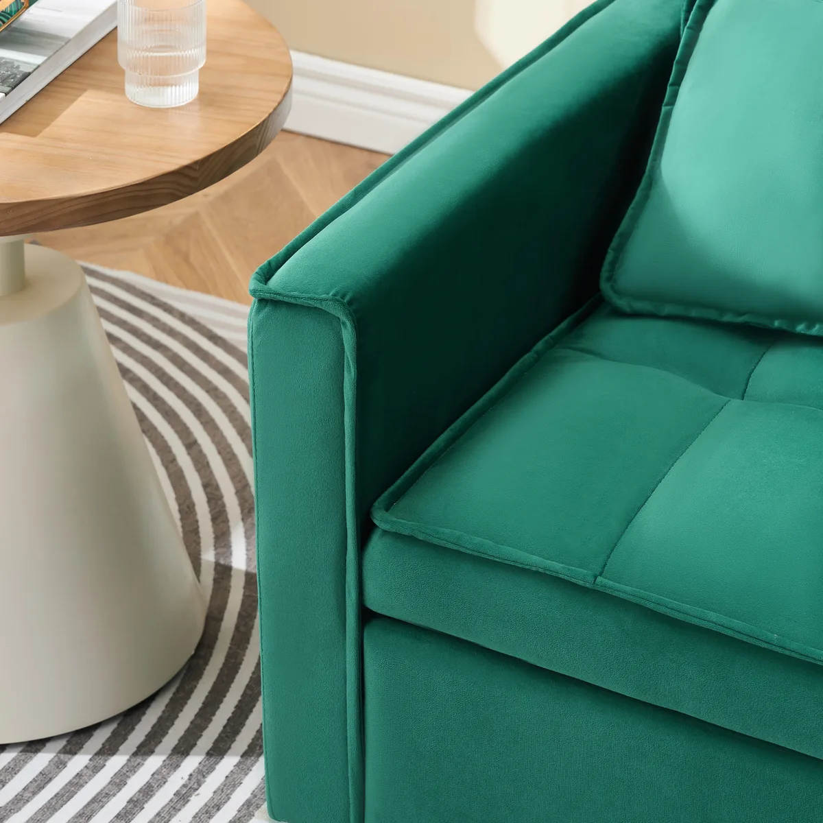 Green velvet sofa bed with curved backrest and side pockets