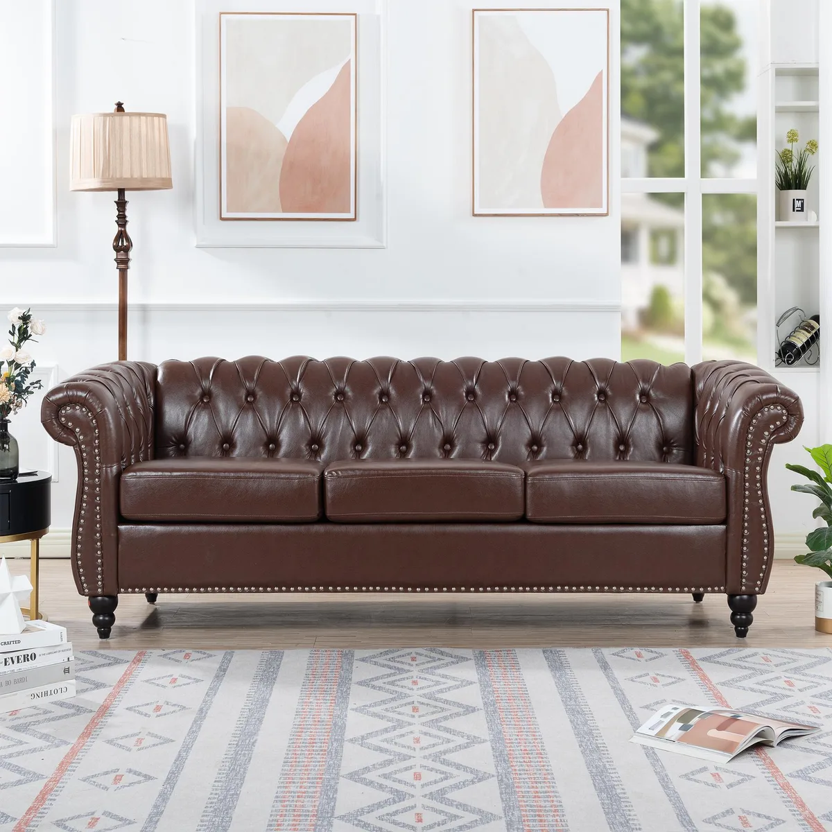 Dark brown PU Chesterfield three-seater sofa with rolled arms and deep button tufting