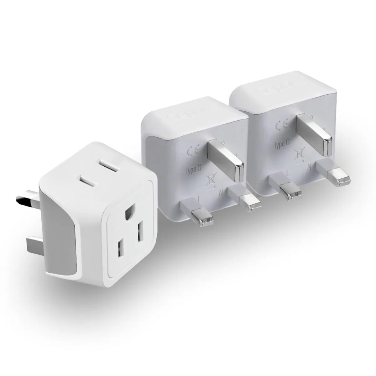 Three white Type G travel adapters with dual US inputs