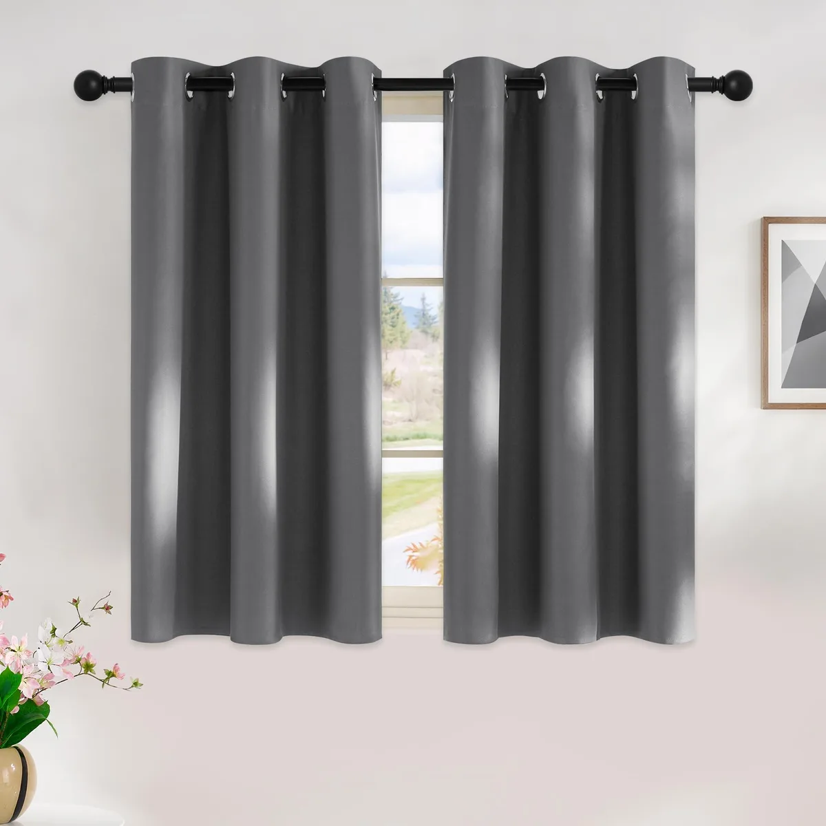 Two grey blackout curtain panels with silver grommets laid flat