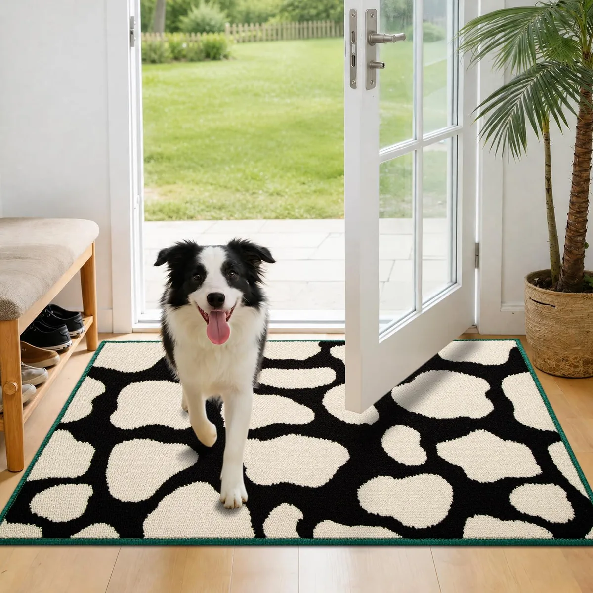 Black rectangular polypropylene door mat with cow print pattern and contrast binding, 36 by 24 inches