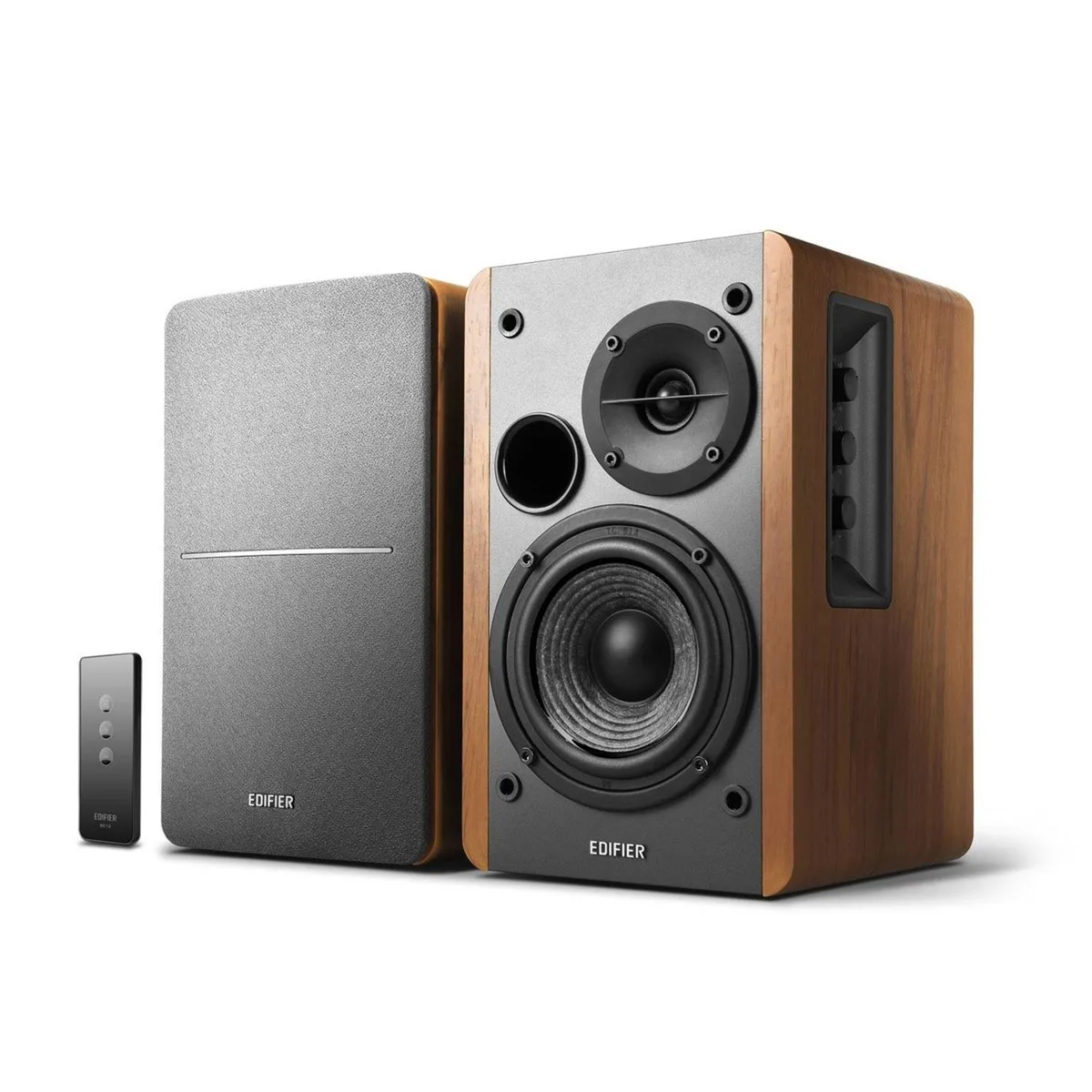 Pair of brown wood-finish bookshelf speakers with front grilles, side controls and remote