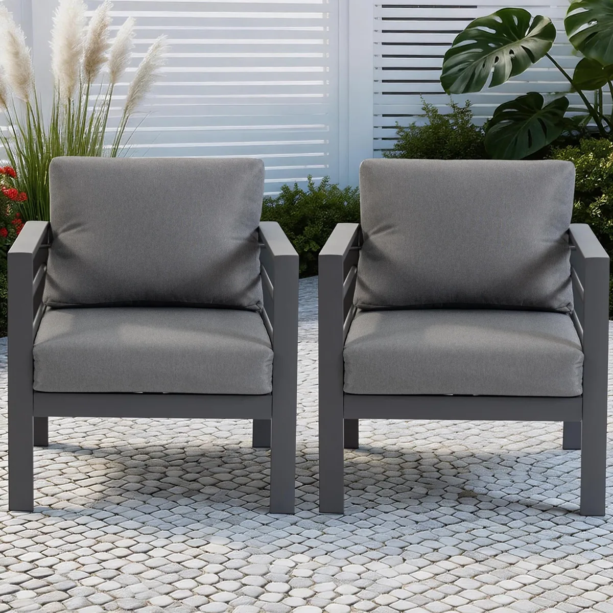 Two grey metal patio chairs with removable cushions and wide armrests