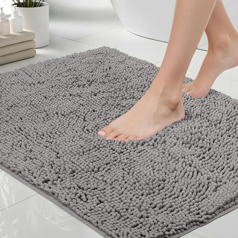 Grey rectangular bath rug with thick chenille pile and rubber backing, 24 by 17 inches