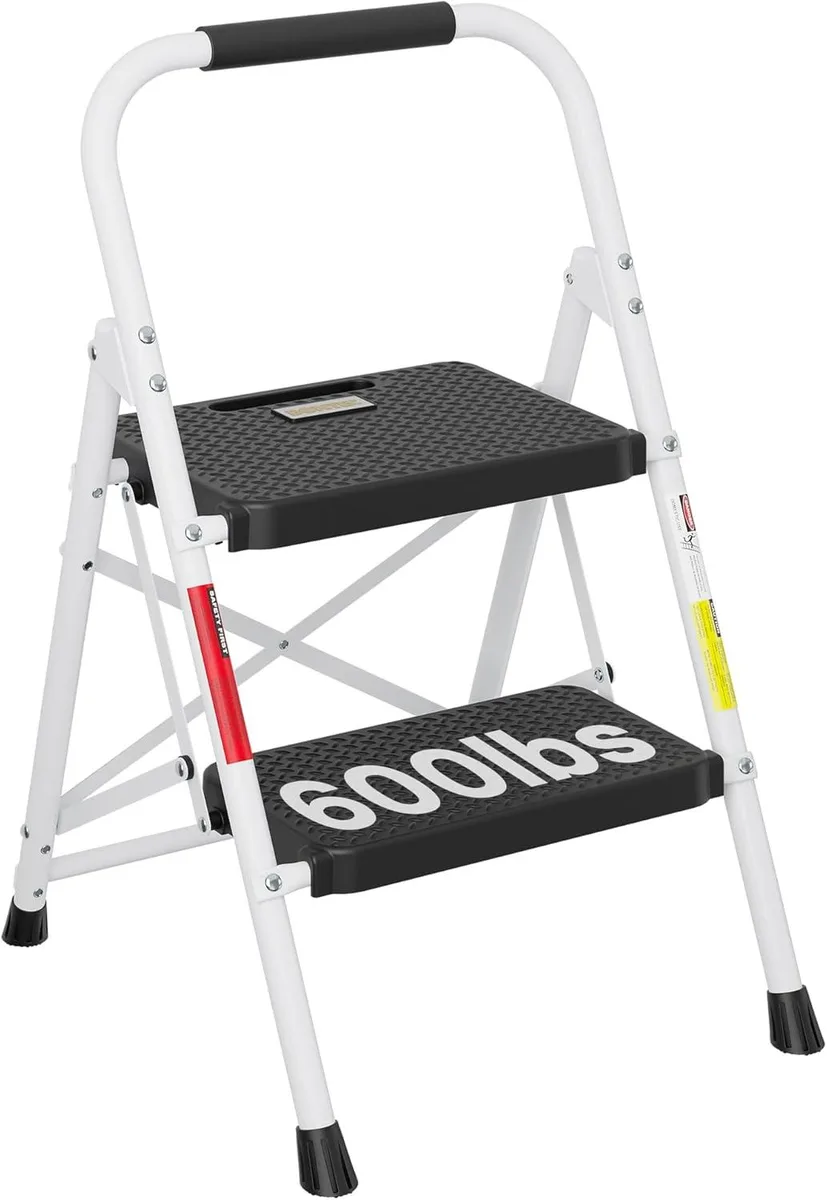 White two-step steel ladder with anti-slip rubber pedals and sponge-covered handrail, folded flat to 2.7 inches thick
