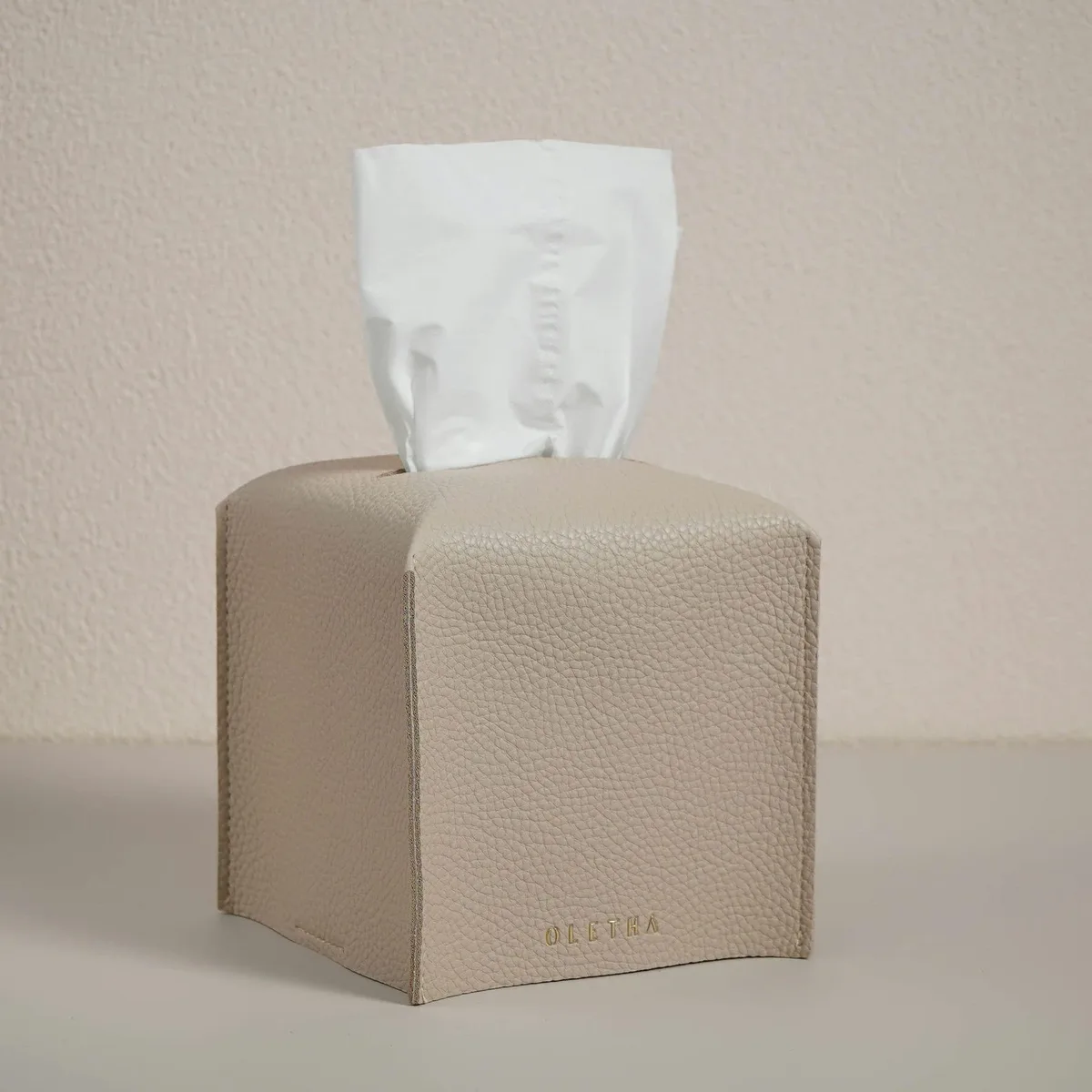Square faux-leather tissue box cover in light taupe with Velcro base