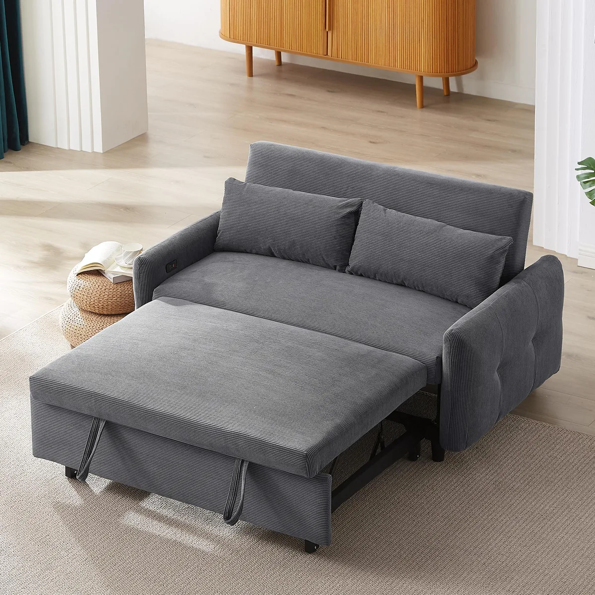 Dark grey corduroy pull-out sofa bed with two throw pillows