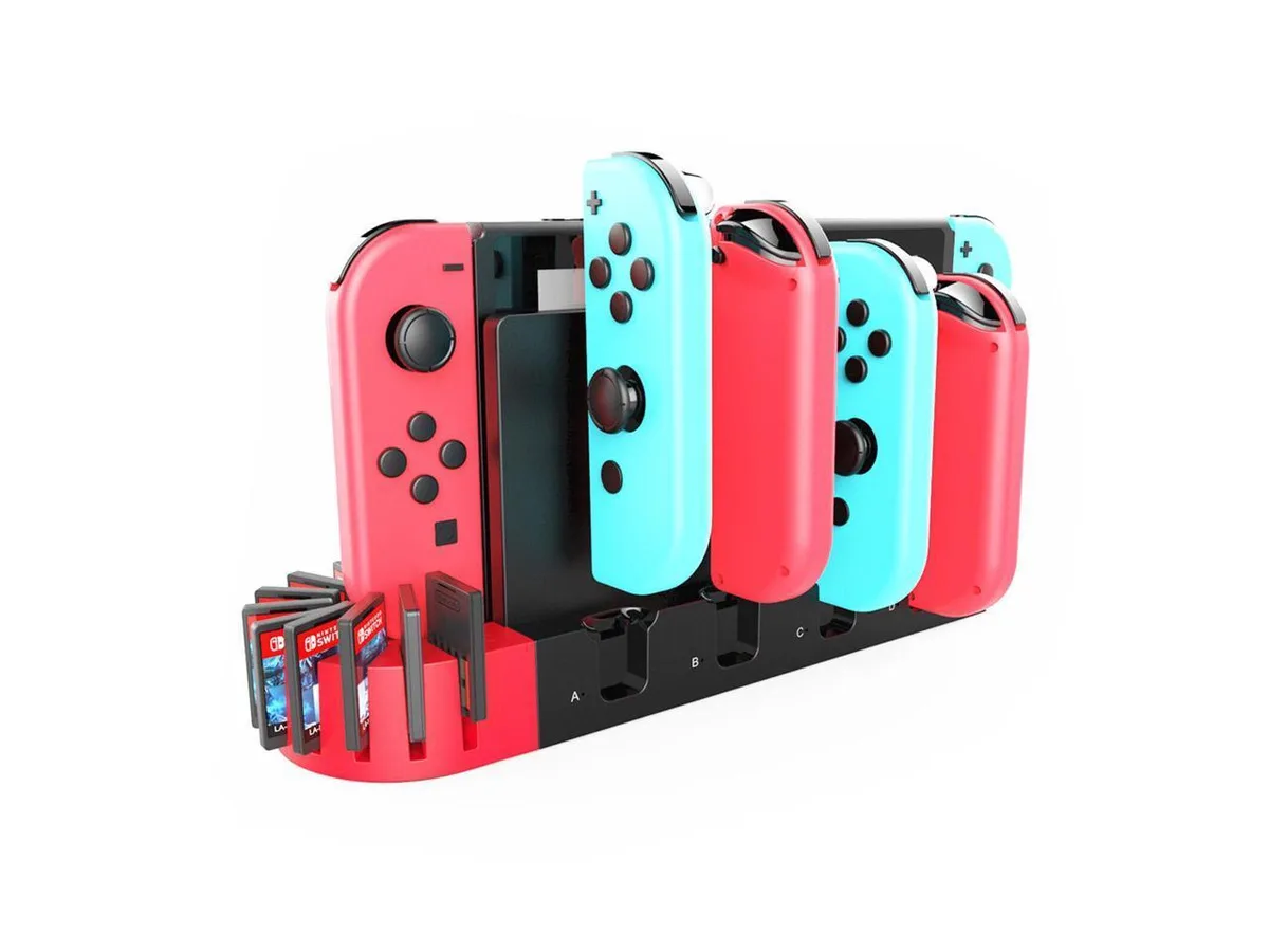White plastic dock charging six Joy-Con controllers with nine game card slots on top