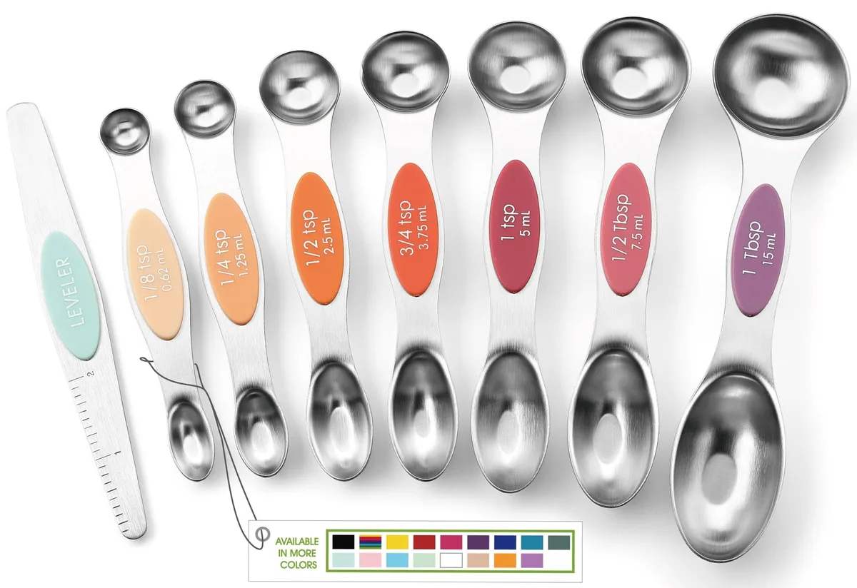 Eight magnetic stainless steel measuring spoons in desert sunset colours, oval and round ends, nested together
