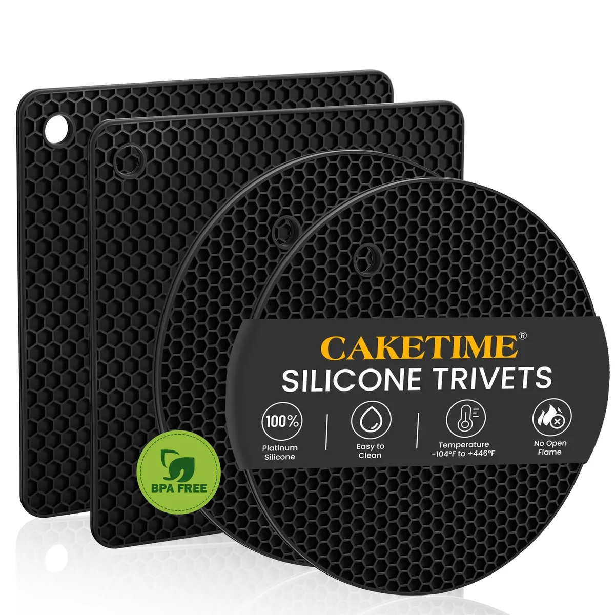 Four black silicone trivets with honeycomb pattern, square shape, matte finish