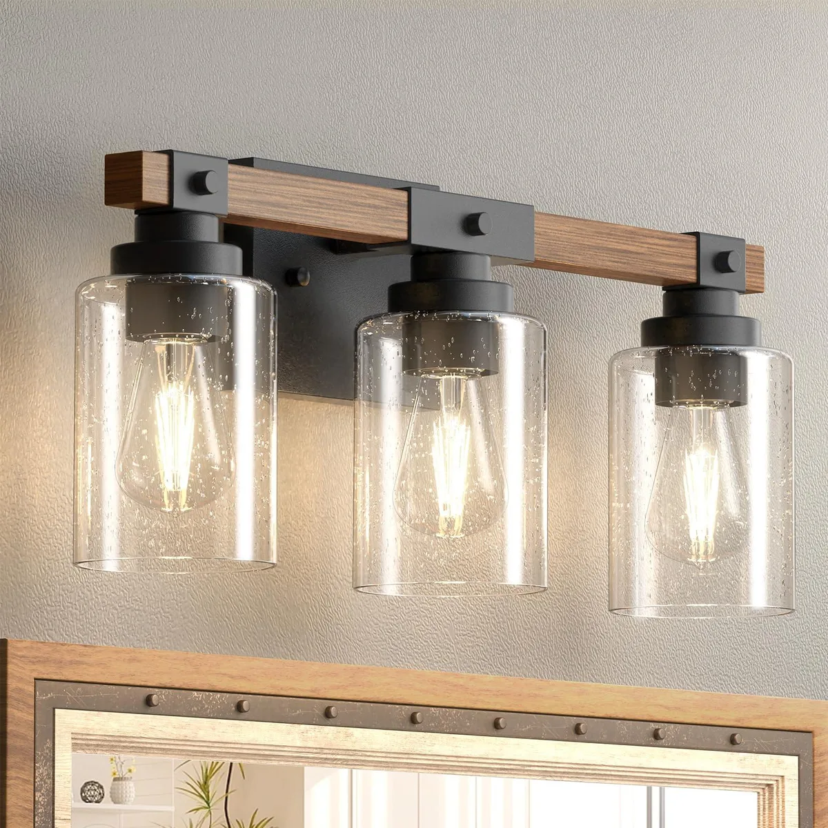 Black metal wall sconce with three seeded glass shades and wood-look frame