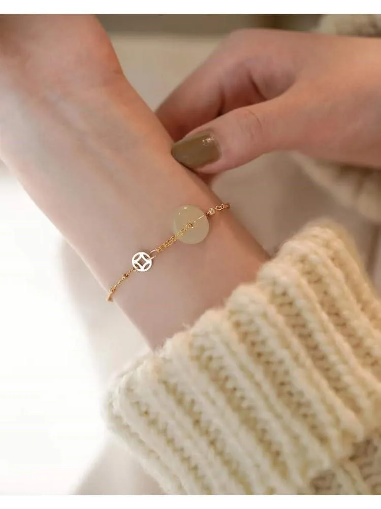 Light green Hetian jade peace buckle bracelet with 14k gold accent, smooth round form