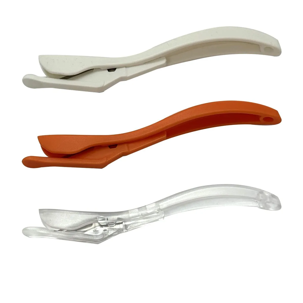 Three handheld wrapping-paper cutters with steel blades in multicoloured plastic handles