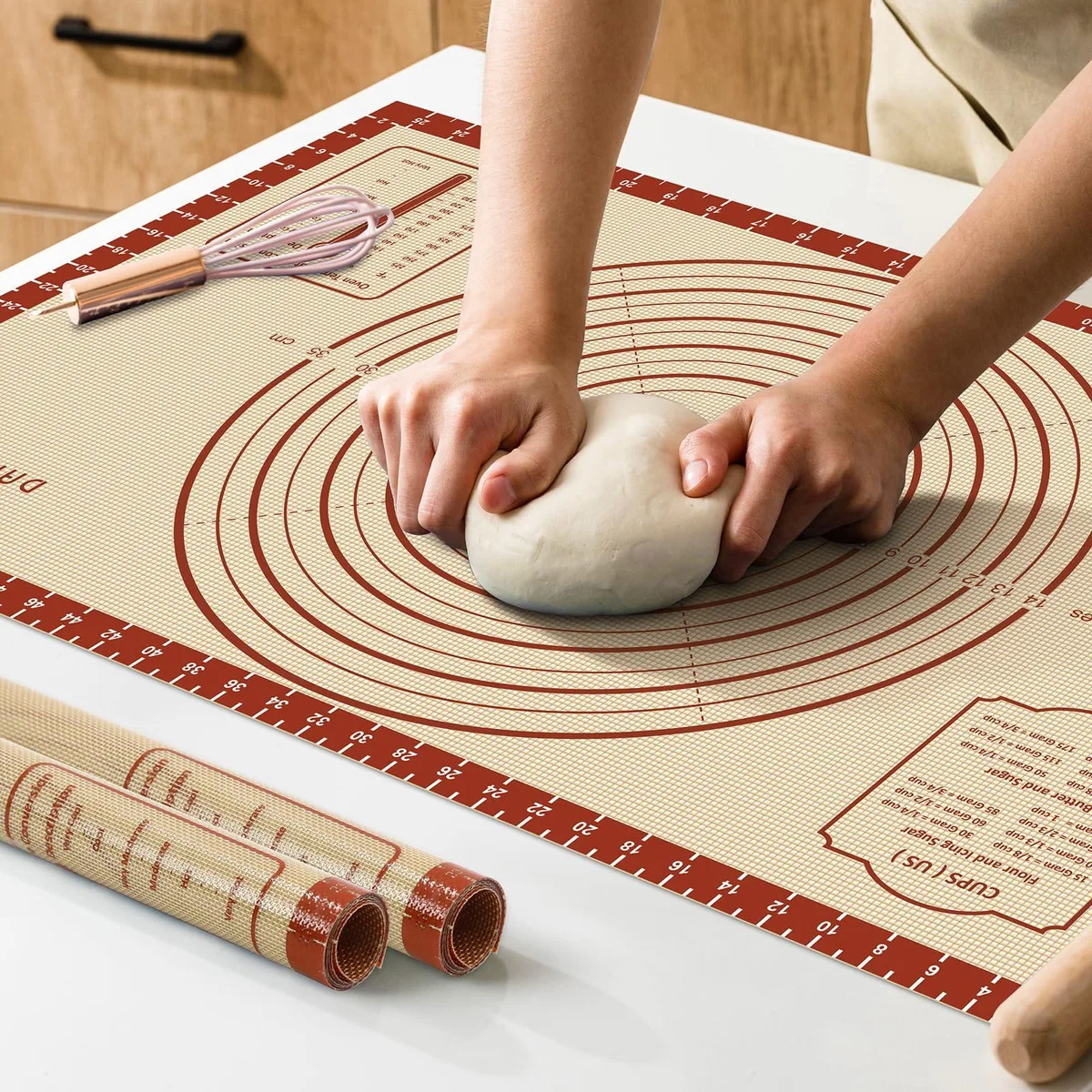 Rectangular light-coloured silicone baking mat with printed grid measurements and reinforced edges