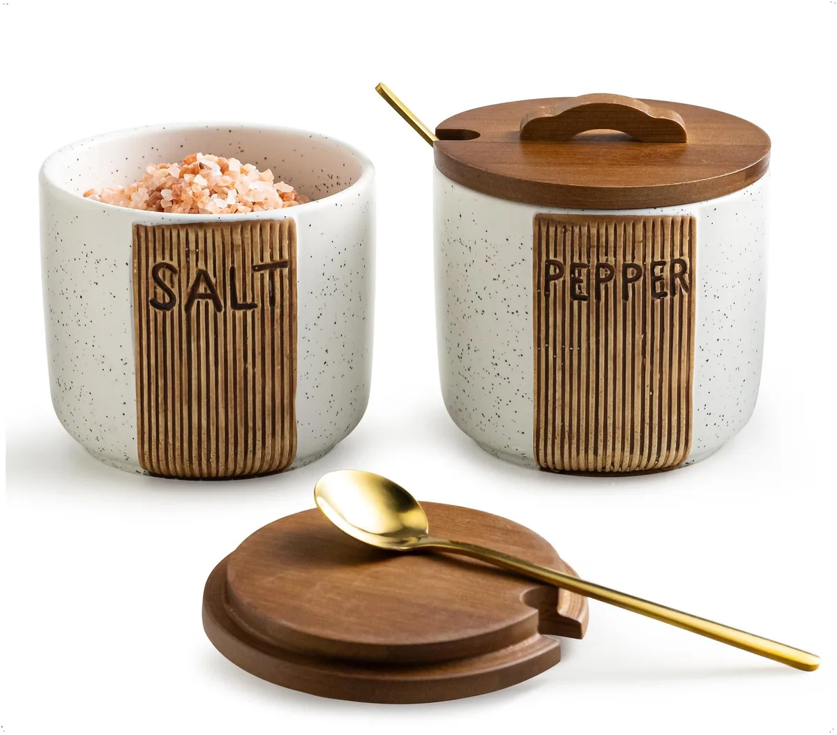 Two white ceramic salt cellars with woodgrain texture, wooden lids and metal spoons