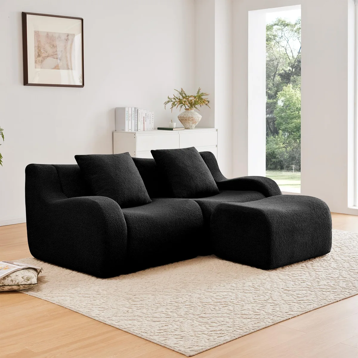 Black L-shaped two-seat sofa in teddy fabric with curved armrests