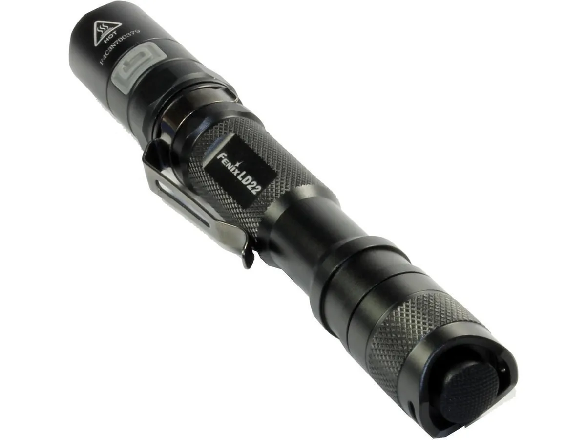 Black cylindrical AA flashlight, textured aluminium body, push-button tail switch, side mode button, clear lens