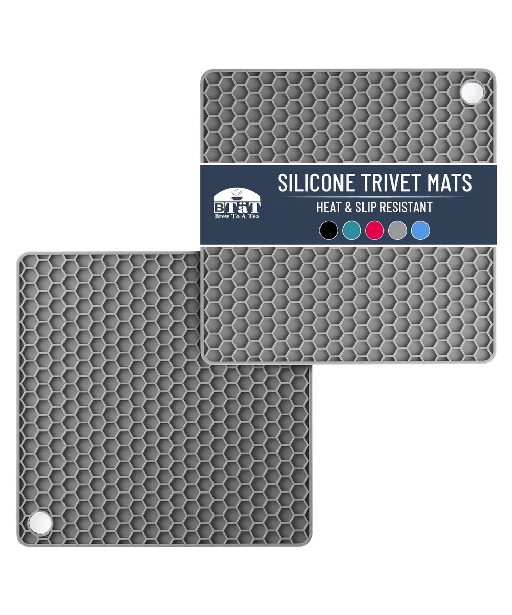 Two grey silicone trivet mats with honeycomb pattern and hanging holes
