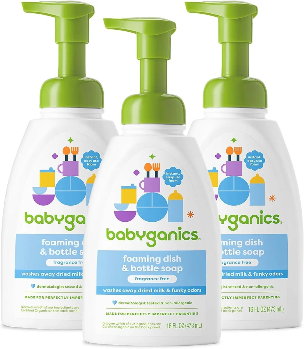 Three white pump bottles with green caps standing together