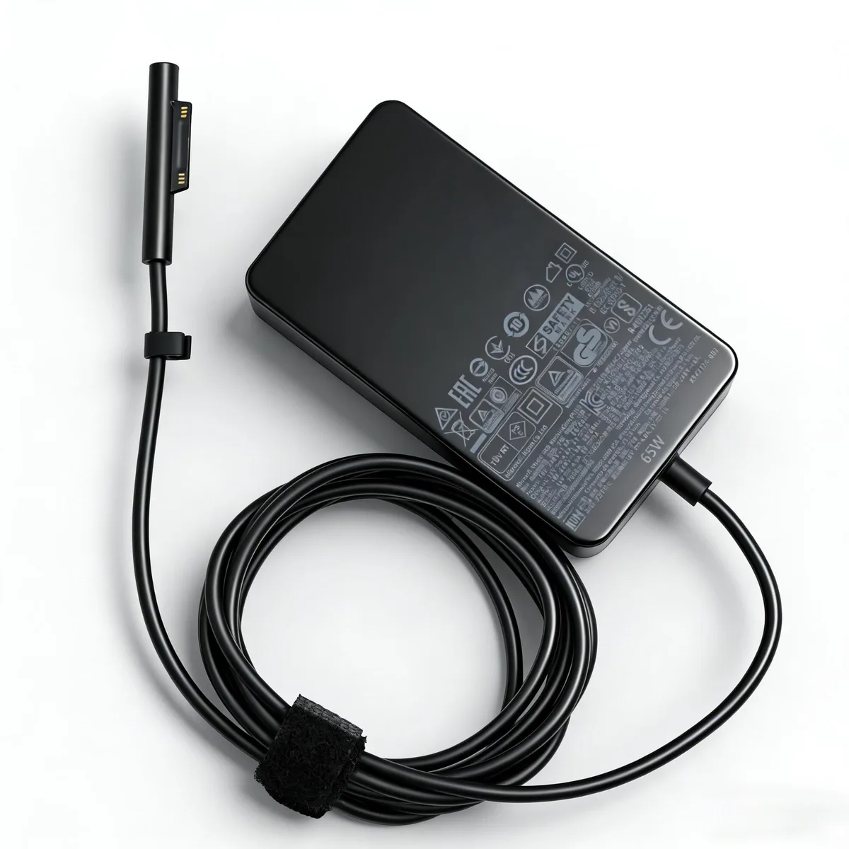 Compact black rectangular 65W AC adapter with Surface Connect cable and detachable two-pin mains lead