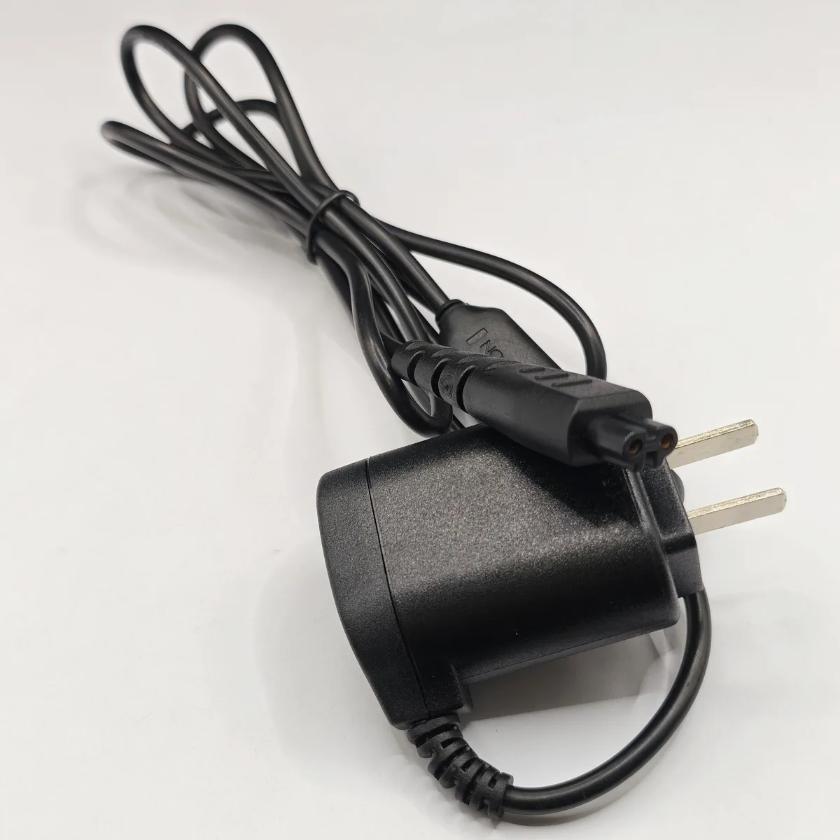 Black rectangular shaver charger with rounded edges and matte finish
