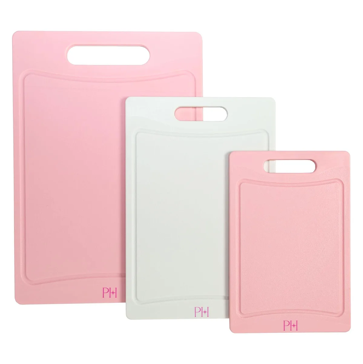 Three pink and cream plastic cutting boards with juice grooves and handles