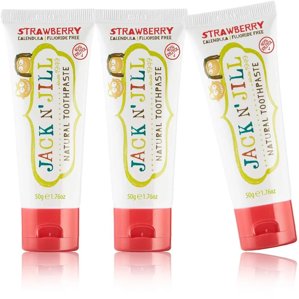 Three small strawberry toothpaste tubes in a row