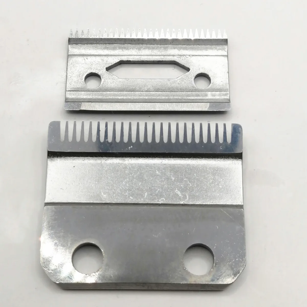 Silver metal clipper blade with two mounting holes