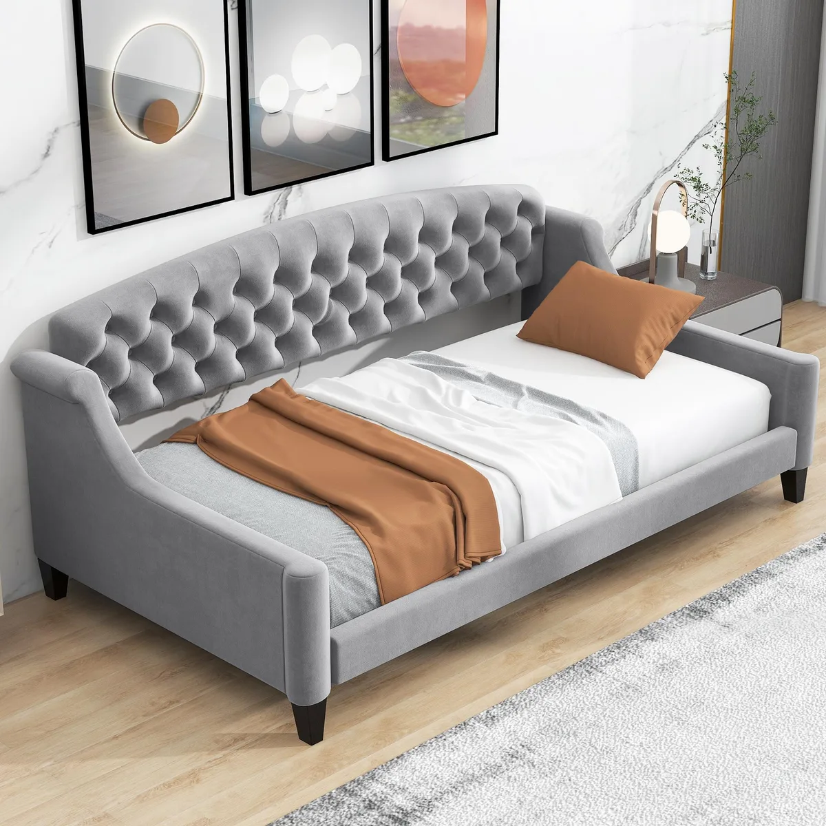 Tufted gray upholstered twin daybed with wooden slats and legs