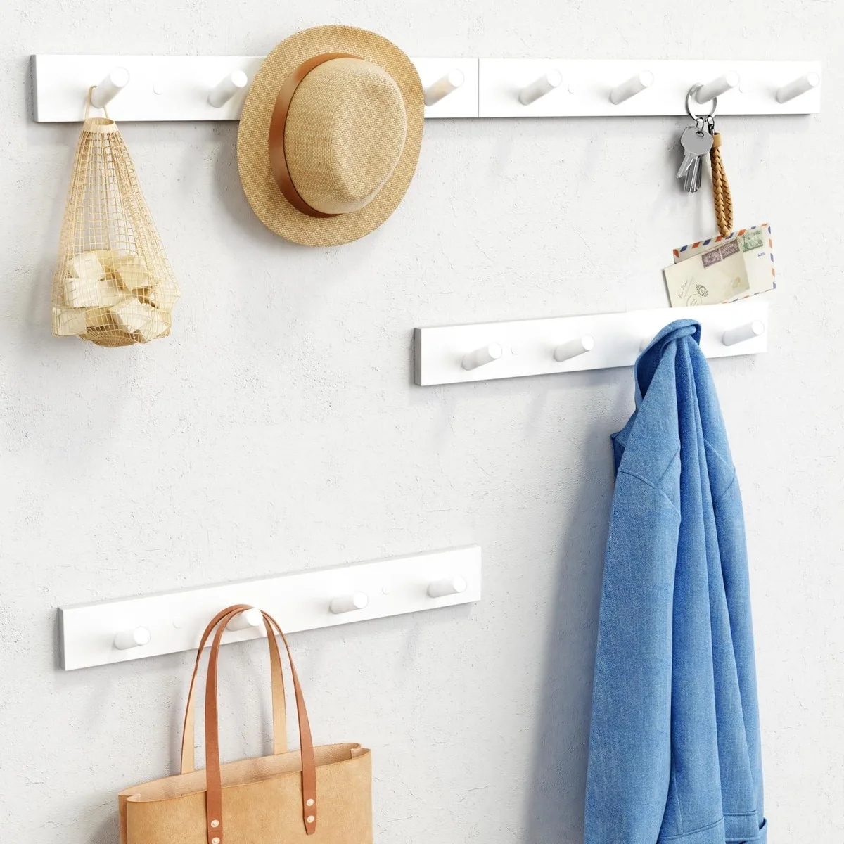 White wall-mounted coat rack with 16 hooks in a row