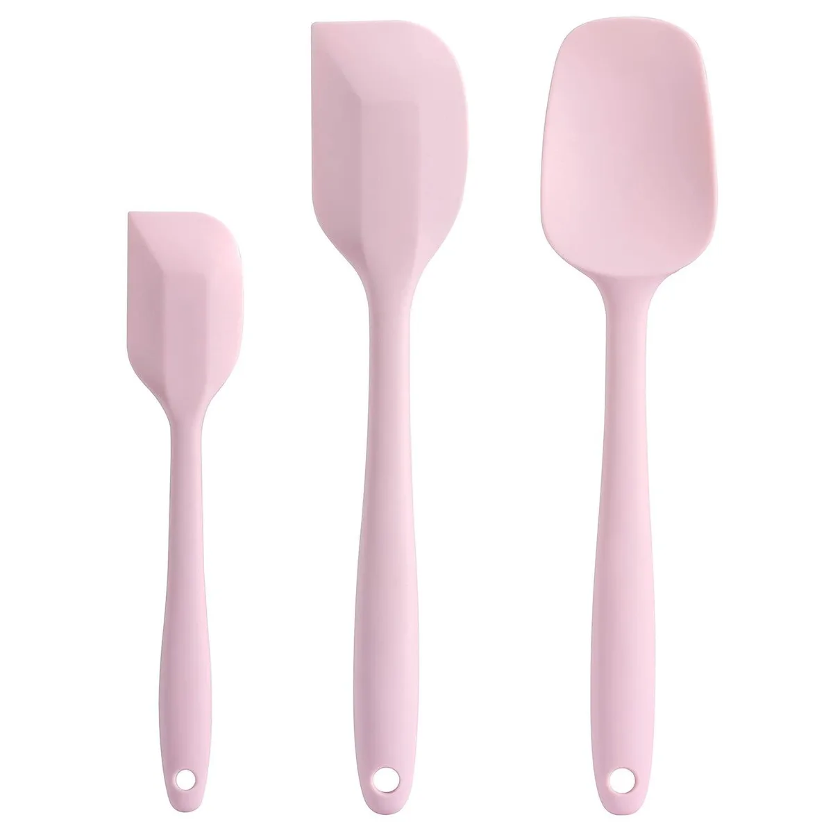 Three pink silicone spatulas on a light surface