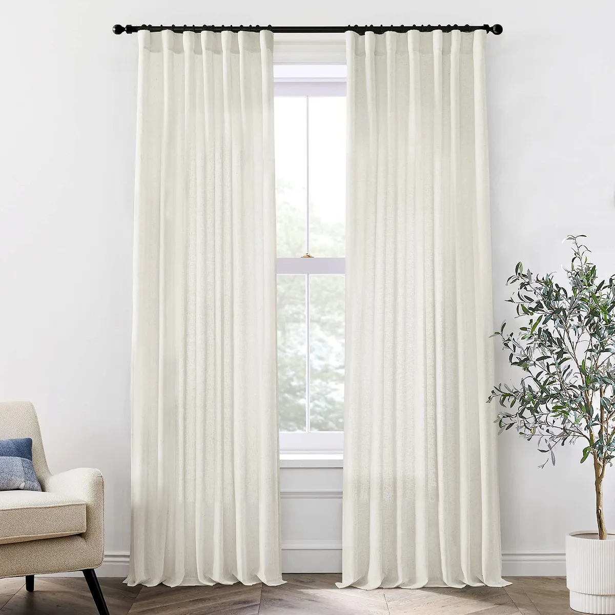 Two ivory semi-sheer curtain panels 50 inches wide by 84 inches long with pleated top and back tabs