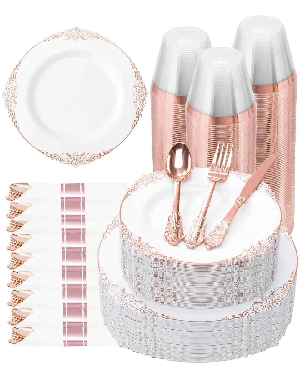 Rose gold rimmed white plastic plates, silver cutlery, napkins and cups packed in a cardboard box