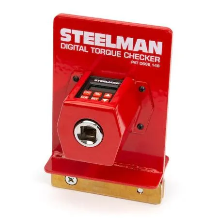 Handheld digital torque checker with powder-coated steel housing and brass mounting pads, shown in blow-molded plastic case