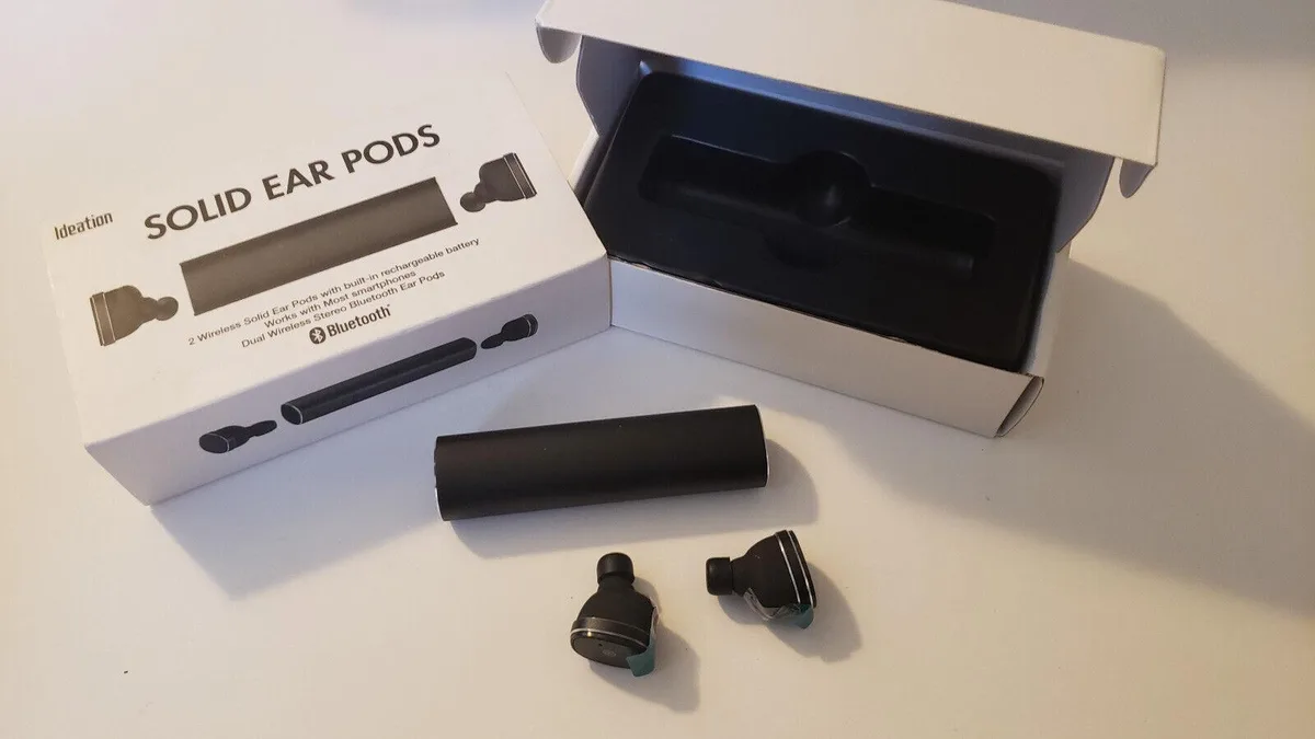 Black wireless ear pods in a rectangular charging case with micro USB port